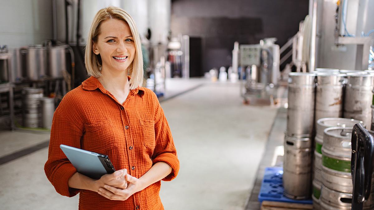 Worker standing in front of kegs in a warehouse