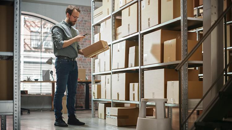 Worker holding a box in a storage room