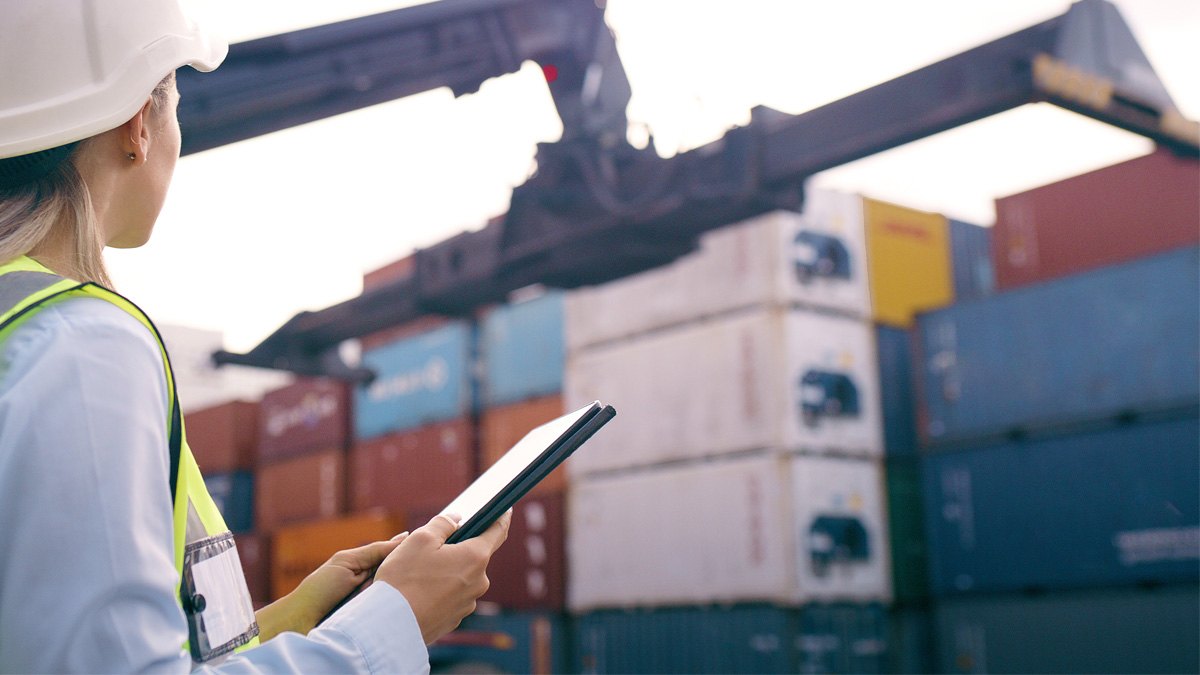 Port services employee inspecting containers